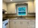 Practical kitchen with white cabinets, granite countertops, and a double stainless steel sink at 5734 Brookhaven Rd, Charlotte, NC 28210