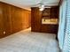 Cozy living space with wood-paneled walls and tile flooring, featuring built-in shelving and a window with blinds at 5734 Brookhaven Rd, Charlotte, NC 28210