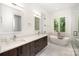 Bright bathroom featuring a modern soaking tub, double vanity with quartz countertop, and marble tile flooring at 5925 Creola Rd, Charlotte, NC 28270