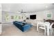 Open-concept living room featuring a blue sectional sofa, entertainment center, and bright windows at 5925 Creola Rd, Charlotte, NC 28270