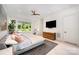 Bright main bedroom with hardwood floors, sitting area, desk, and large window views of the backyard at 5925 Creola Rd, Charlotte, NC 28270