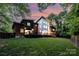 Modern home boasting a large deck, multi-pane windows, and lush green yard at dusk at 5925 Creola Rd, Charlotte, NC 28270