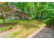 Backyard of brick apartments featuring balconies, patios and grassy lawn at 5927 Quail Hollow Rd # H, Charlotte, NC 28210