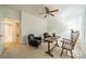 Well-lit bedroom featuring two chairs, neutral carpet, ceiling fan, and a view into another room at 5927 Quail Hollow Rd # H, Charlotte, NC 28210