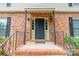 Townhouse entrance featuring brick facade, black door with sidelights, and access to apartments above at 5927 Quail Hollow Rd # H, Charlotte, NC 28210