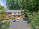 Exterior view of brick townhomes with parking, landscaping, and mature trees at 5927 Quail Hollow Rd # H, Charlotte, NC 28210