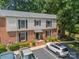 Exterior of townhome with brick and vinyl siding, lush landscaping, and paved parking at 5927 Quail Hollow Rd # H, Charlotte, NC 28210