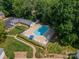 Aerial view of the community pool with lounge chairs and umbrella, surrounded by mature trees at 5927 Quail Hollow Rd # H, Charlotte, NC 28210