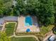 Aerial view of the community pool with lounge chairs, umbrellas, and landscaping at 5927 Quail Hollow Rd # H, Charlotte, NC 28210