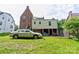 Back of home featuring a two-story brick facade and a car parked in the yard at 611 E Marion St, Shelby, NC 28150