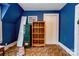 A blue room with a low slanting ceiling featuring a bookshelf and painted blue walls at 611 E Marion St, Shelby, NC 28150