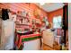 A pink laundry room cluttered with cleaning supplies and featuring a vintage ceiling fan at 611 E Marion St, Shelby, NC 28150