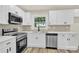 Beautiful kitchen boasting bright white cabinets, stainless steel appliances and new countertops at 6328 Beecher Dr, Charlotte, NC 28215