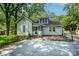 Back exterior showing a backyard with a brick patio and mature trees at 636 N Center St, Statesville, NC 28677