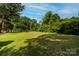Large, private backyard with a lush lawn and surrounding trees at 636 N Center St, Statesville, NC 28677