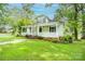 Charming home featuring a spacious front porch, lush green lawn, and mature trees offering shade at 636 N Center St, Statesville, NC 28677