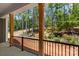 Cozy back porch with wooden columns, black railings, and a view of the wooded backyard at 6782 Kingfisher Ct, Denver, NC 28037