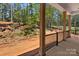 Spacious back porch with wooden columns, black railings, and a view of the wooded backyard at 6782 Kingfisher Ct, Denver, NC 28037