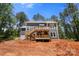 View of the backyard deck with a staircase leading to the lower level and unfinished landscaping at 6782 Kingfisher Ct, Denver, NC 28037