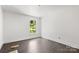 Bedroom featuring a bright window, white trim and dark wood floors at 6782 Kingfisher Ct, Denver, NC 28037