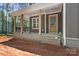 Charming front porch with wooden columns, black railings, and a wooden front door at 6782 Kingfisher Ct, Denver, NC 28037