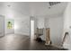 Spacious living room with dark wood floors, and a staircase with natural light from the window at 6782 Kingfisher Ct, Denver, NC 28037