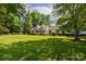 Exterior shot of the home featuring a lush green lawn, mature trees, and tasteful landscaping at 785 Sanside Dr, York, SC 29745
