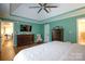 Well-lit main bedroom featuring a ceiling fan, tray ceilings, hardwood flooring, and an ensuite bathroom at 785 Sanside Dr, York, SC 29745