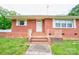 Classic brick home featuring a welcoming front entrance with steps, railings, and a storm door at 800 Charles Rd, Shelby, NC 28150
