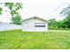 View of the detached garage with a white fence, surrounded by a grassy lawn at 800 Charles Rd, Shelby, NC 28150