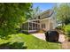 Backyard featuring a screened porch, stone patio, lush lawn, mature trees, and an outdoor grill at 8441 Sandowne Ln, Huntersville, NC 28078