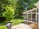 Backyard view featuring a screened porch, a well-manicured lawn, stone patio, and beautiful mature trees at 8441 Sandowne Ln, Huntersville, NC 28078
