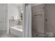 Bathroom featuring a modern shower with tile surround and built-in niche with tub at 8441 Sandowne Ln, Huntersville, NC 28078