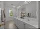 Bright bathroom featuring double sinks, large mirror, and modern fixtures at 8441 Sandowne Ln, Huntersville, NC 28078