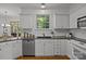 Well-lit kitchen features white cabinets, stainless steel appliances, and granite countertops at 8441 Sandowne Ln, Huntersville, NC 28078