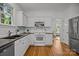 White kitchen with stainless steel appliances, hardwood floors, and granite counters at 8441 Sandowne Ln, Huntersville, NC 28078
