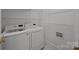 Bright laundry room equipped with modern washer and dryer, plus storage shelving at 8441 Sandowne Ln, Huntersville, NC 28078