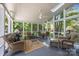 Relaxing screened porch with wicker furniture and views of the lush backyard at 8441 Sandowne Ln, Huntersville, NC 28078