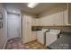 Bright laundry room with white cabinets, modern appliances, and granite countertops at 9002 Fair Oak Dr, Sherrills Ford, NC 28673