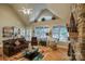 Inviting living room featuring a vaulted ceiling, stone fireplace, and scenic views of nature at 9002 Fair Oak Dr, Sherrills Ford, NC 28673