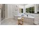 Bright bathroom featuring soaking tub under a window, with tiled floors at 9104 Kingsmead Ln, Waxhaw, NC 28173