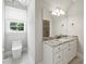 Bathroom with a modern toilet, sleek vanity, and granite countertop with large mirror and contemporary lighting at 9104 Kingsmead Ln, Waxhaw, NC 28173