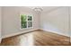 Empty bedroom with hardwood floors, neutral paint, and natural light offers a flexible living space at 9104 Kingsmead Ln, Waxhaw, NC 28173