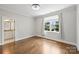 Bright bedroom features hardwood floors, modern lighting, and a large window overlooking a beautifully landscaped yard at 9104 Kingsmead Ln, Waxhaw, NC 28173