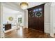 Grand foyer with hardwood flooring, chandelier, and office view at 9104 Kingsmead Ln, Waxhaw, NC 28173