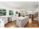 Modern kitchen with white cabinets, a center island, stainless steel appliances, and hardwood flooring at 9104 Kingsmead Ln, Waxhaw, NC 28173