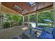 Inviting covered brick patio with wood ceiling, fan, and comfortable seating overlooking the backyard pool at 9104 Kingsmead Ln, Waxhaw, NC 28173