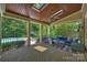 Inviting covered brick patio with wood ceiling, fan, and comfortable seating overlooking the backyard pool at 9104 Kingsmead Ln, Waxhaw, NC 28173