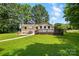 Spacious backyard featuring a well-maintained lawn, patio furniture, and a charming deck, perfect for entertaining at 103 W Sunset Dr, Locust, NC 28097