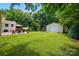 Expansive backyard showcasing a well-manicured lawn, patio seating, detached garage, and a playset at 103 W Sunset Dr, Locust, NC 28097